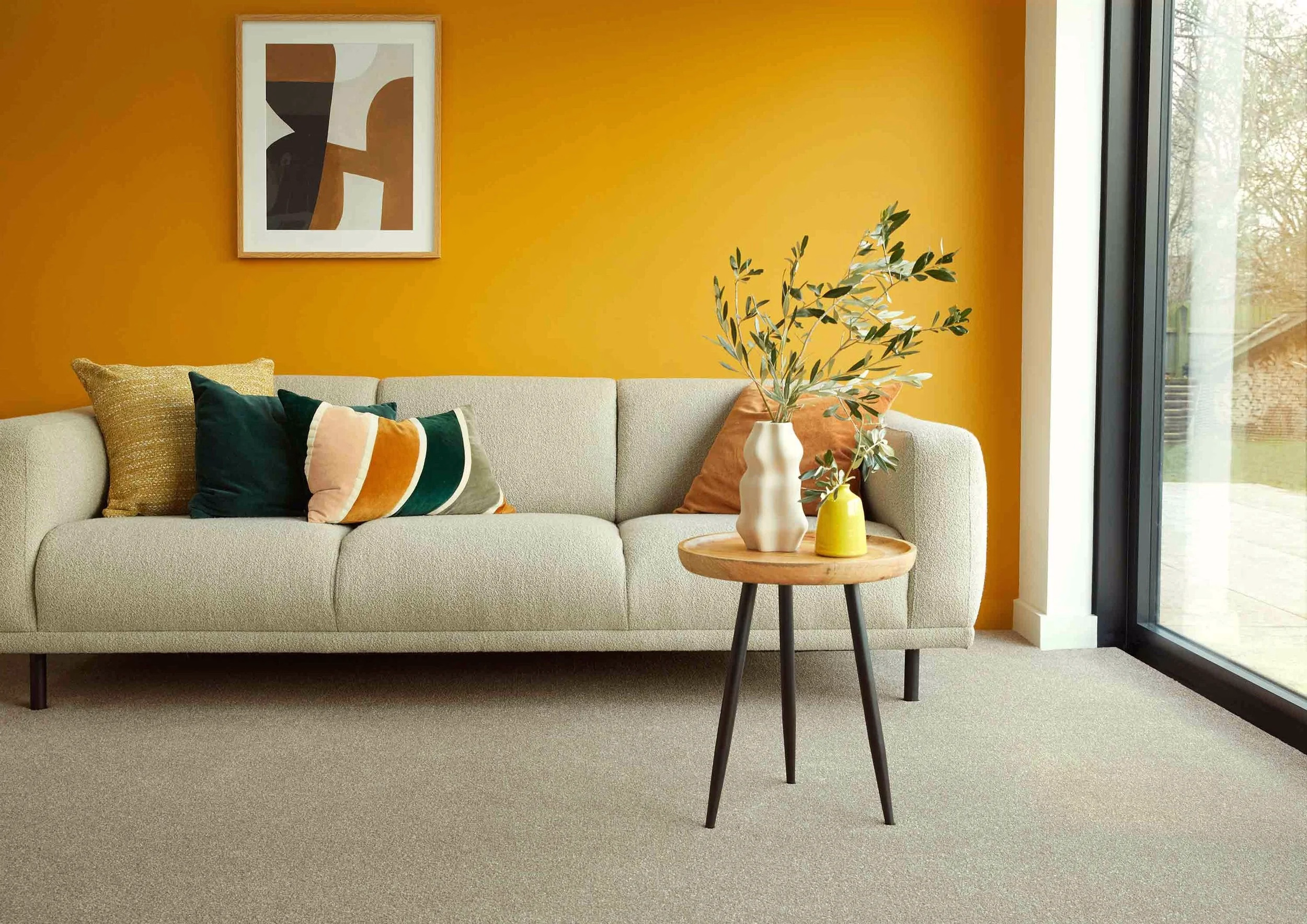 Light neutral carpet in a living room with an orange feature wall