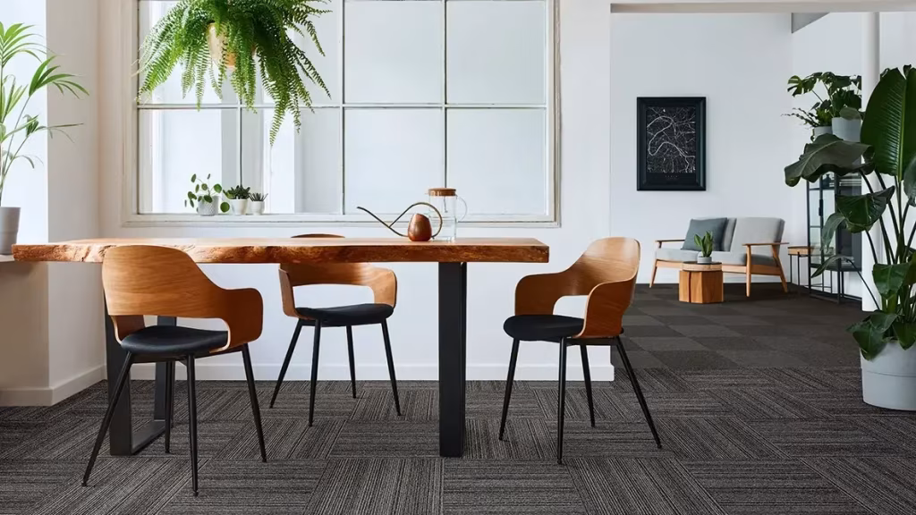 Dark patterned carpet tiles in a bright dining and workspace
