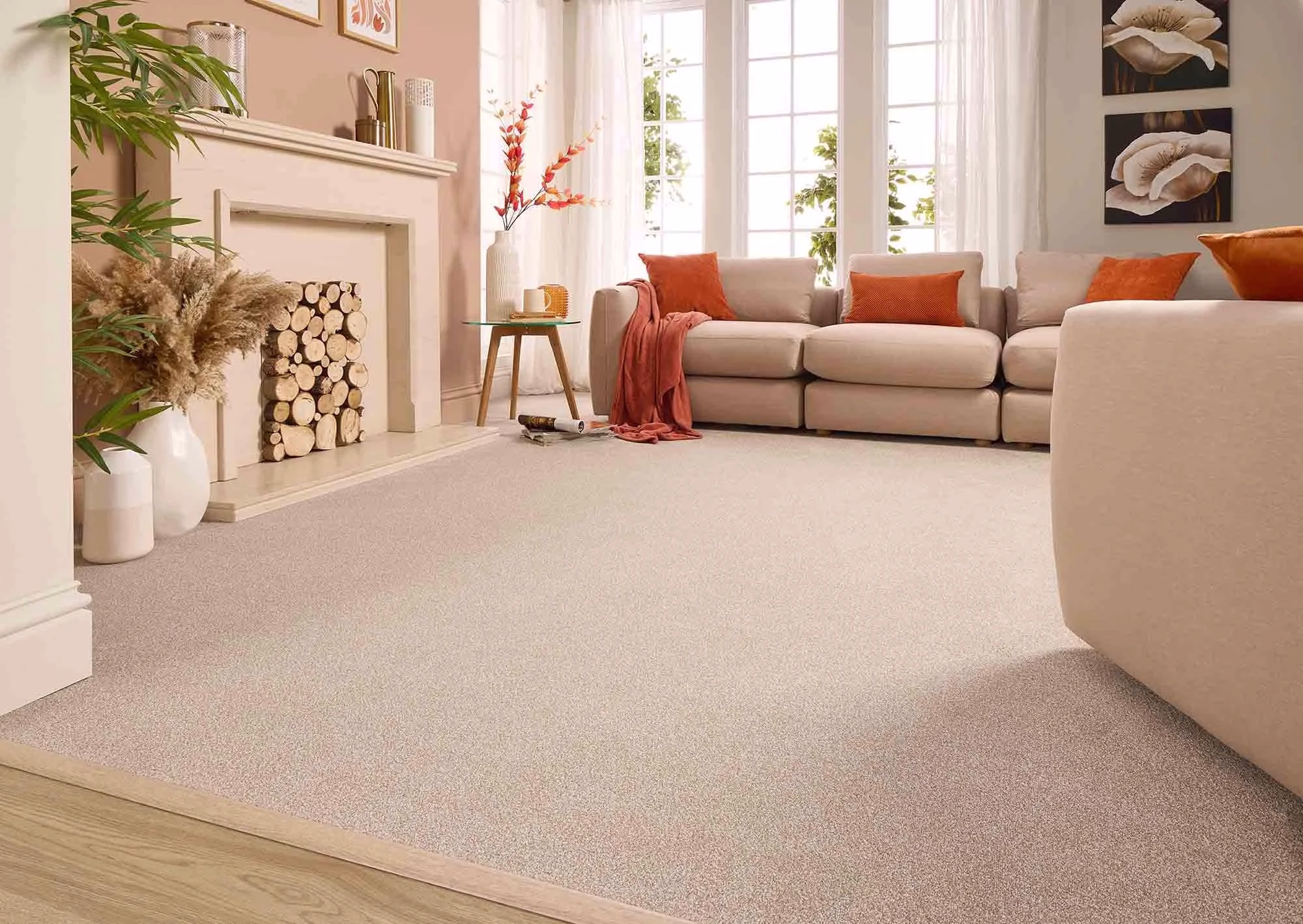 Pale carpet in a bright living room with orange cushions