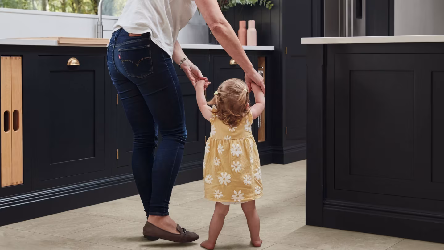 Mother and child standing on stone-effect vinyl flooring in a kitchen